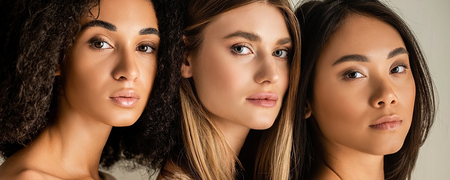 Three diverse women posing together.