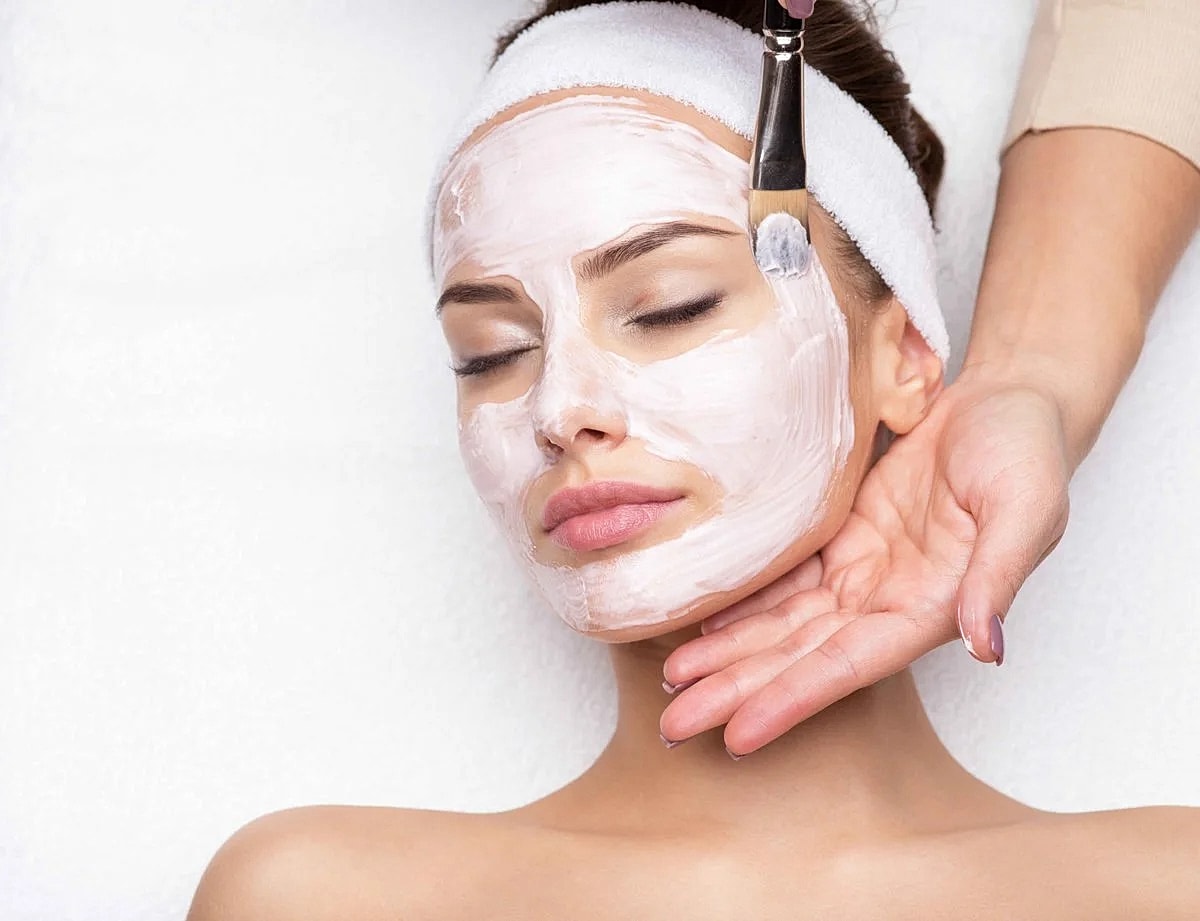 Woman receiving facial treatment in spa setting