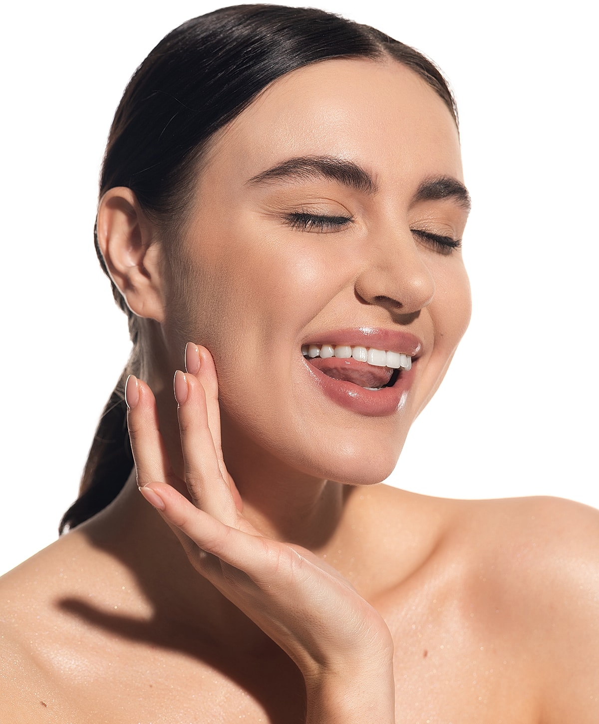 Smiling woman with radiant skin and playful expression.