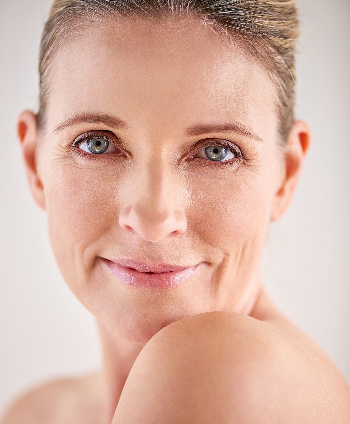 Smiling woman with blue eyes and soft complexion.