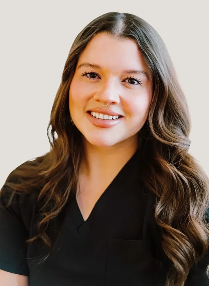 Smiling woman in black scrub top portrait.