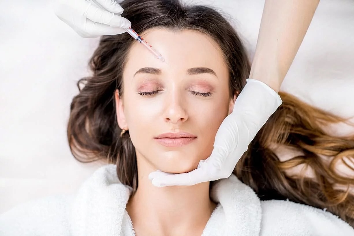 Woman receiving cosmetic treatment on her forehead.