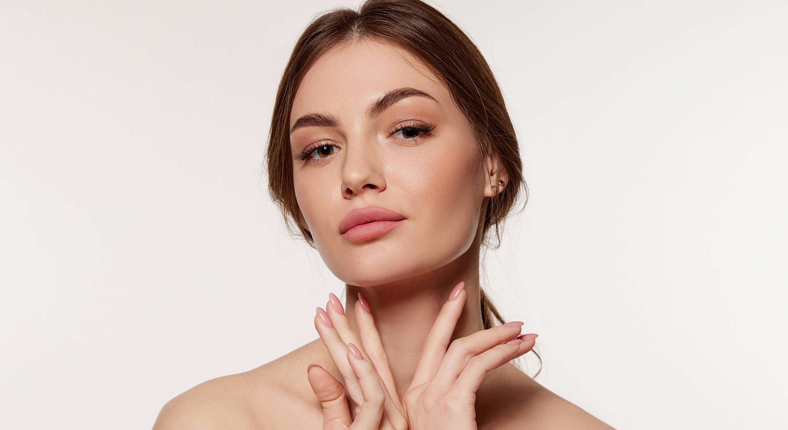 Woman with hands on face, soft expression.