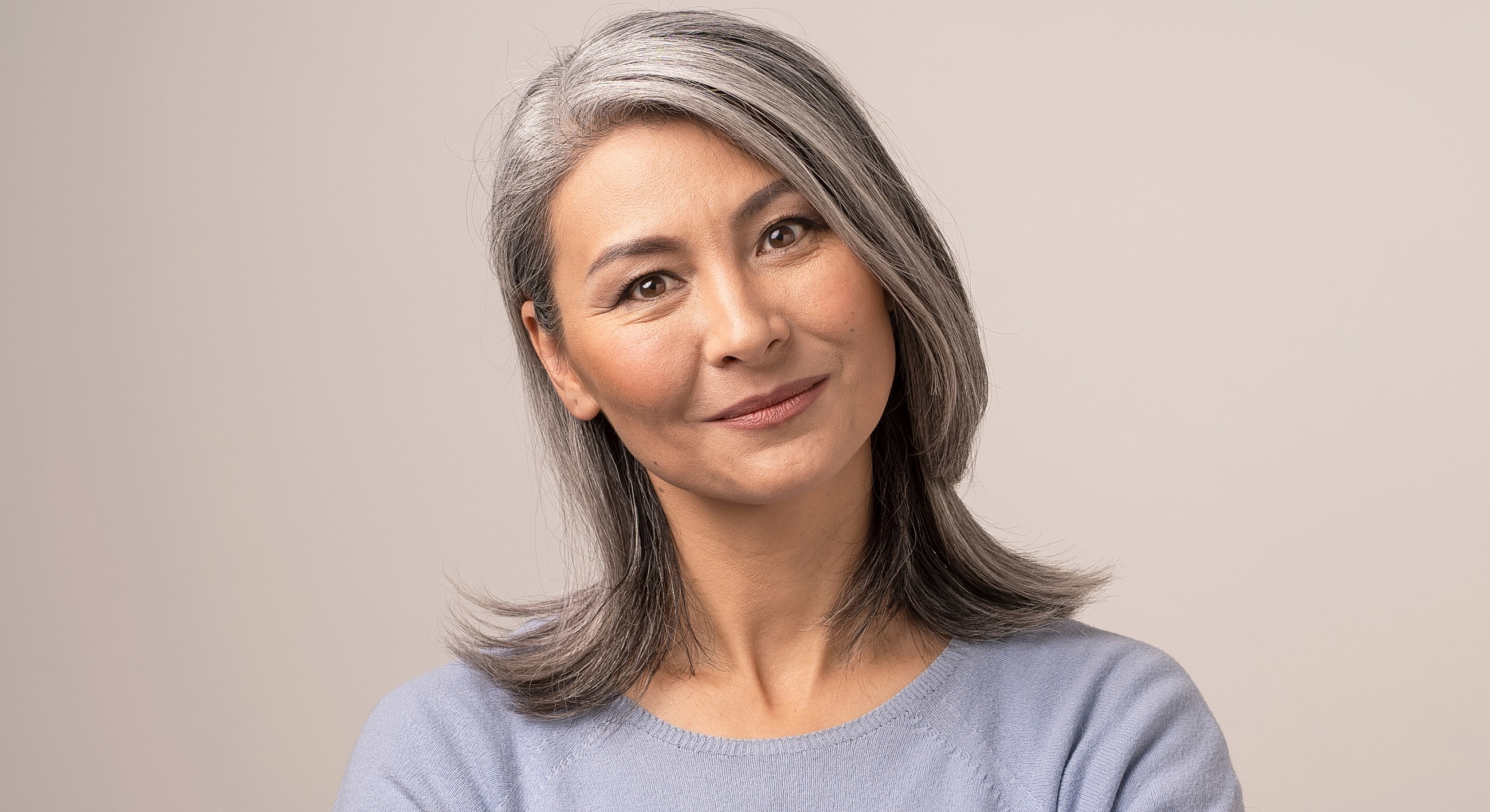 Smiling woman with gray hair and blue sweater